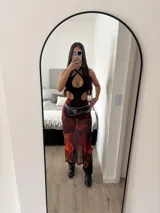 Pareo largo de malla traslúcida con estampado de llamas en tonos rojo, naranja y negro.