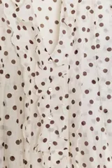 Blusa de escote en pico con volantes frontales, manga larga con puños elásticos y cierre frontal con botones.
