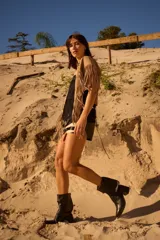 Botas cortas de gamuza color marrón, con taco cuadrado y punta ligeramente elevada. Presentan un detalle de trenzado decorativo en la parte superior de la caña.