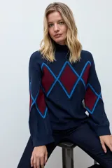 Sweater de punto con cuello alto, diseño de rombos en tonos azul marino, bordó y azul eléctrico, con mangas largas y terminaciones acanaladas.