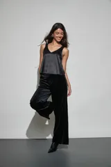 Pantalon de vestir negro de corte recto y tiro alto, confeccionado en tela de terciopelo con acabado brillante.