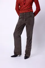 Pantalón de tiro alto confeccionado en pana color óxido. Presenta cierre frontal con botonadura metálica, bolsillos plaqué laterales y diseño de pierna flare.