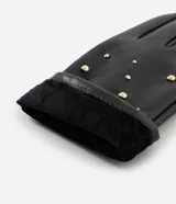 Guantes de cuero sintético color negro, con diseño de tachuelas metálicas doradas distribuidas en el dorso. Cuentan con forro interior para mayor calidez.