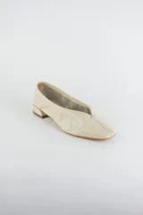 Mocasines de cuero metalizado color gris, con diseño de punta cuadrada y costura central fruncida en la capellada.