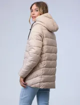 Campera puffer color marrón con capitoneado horizontal. Tiene cuello alto y capucha ajustable con cordones, con el interior del cuello en textura aterciopelada negra. Cierre frontal completo y bolsillos laterales. El corte es ligeramente más largo en la parte posterior con aberturas laterales redondeadas.