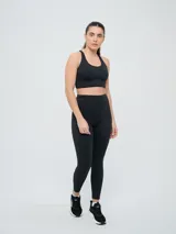 Top deportivo Umbro color negro con diseño de espalda natación y banda elástica inferior.