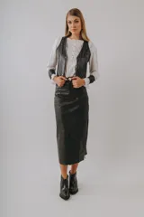 Falda midi negra de efecto cuero, con talle alto y aberturas laterales en el ruedo.