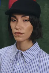 Camisa de corte oversize con estampado a rayas verticales en tonos azul y blanco, cuello clásico y cierre frontal con botones.