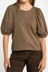 Remera de algodón color blanco, con cuello redondo y mangas globo de largo 3/4 con puños elásticos.