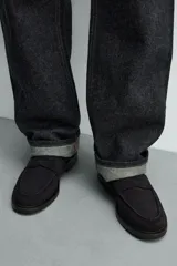 Mocasín de vestir para hombre, confeccionado en piel con acabado serraje (gamuza), color negro. Presenta un detalle de antifaz en el empeine y suela negra a contraste con un ligero tacón.