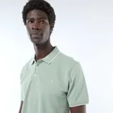 Remera polo de piqué color verde menta, con cuello y puños acanalados en tono contrastante, cierre frontal con botones y bordado sutil en el pecho.