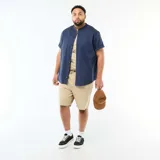 Bermuda estilo chino color beige, con cierre frontal de cremallera, botón y cordón ajustable en la cintura.