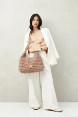 Sweater de tejido de punto color blanco hueso, con cuello redondo y mangas acampanadas. Presenta una hilera de botones a tono en el lateral de cada manga.