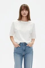 Remera blanca de manga corta y corte holgado, con cuello redondo y diseño de líneas verticales formadas por aplicación de strass.