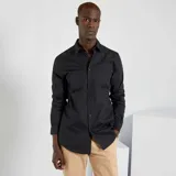 Camisa negra de corte recto, manga larga y cuello clásico.