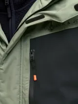 Campera técnica impermeable y cortaviento con capucha ajustable, diseñada para condiciones de frío, viento y lluvia. Confeccionada en tejido resistente, cuenta con cierre frontal con tapeta, bolsillos con cierre, ventilación bajo los brazos y ajustes en puños para evitar la entrada de nieve.