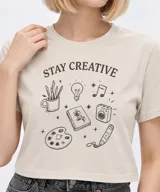 Remera de manga corta de algodón, color blanco, con cuello redondo y estampado frontal estilo collage con gráficos y texto en tono bordó.