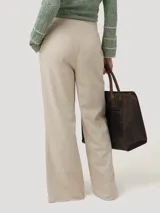 Pantalón de tiro medio color beige, confeccionado en mezcla de lino y viscosa. Presenta un corte recto con aberturas laterales en el bajo y cierre frontal con botón.