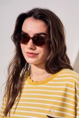 Lentes de sol polarizados de diseño ovalado con armazón carey en tonos marrones y cristales oscuros.