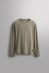 Camiseta de entrenamiento de manga larga color verde militar, con cuello redondo y corte regular fit. Confeccionada en tejido técnico ligero y elástico con estructura Quick Dry nivel 2. Presenta estampado combinado a contraste en la espalda y logo estampado en el bajo.