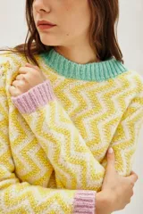 Sweater de punto con diseño de zigzag en tonos amarillo y blanco, cuello redondo, puños en color lila y ruedo en color verde menta.