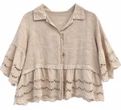 Camisa beige de manga corta con detalles de bordado inglés en las mangas y el ruedo, cierre frontal con botones y cuello camisero.