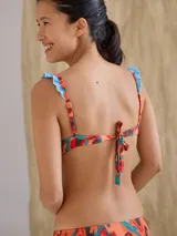 Top de bikini con aro, diseño estampado con tonos vibrantes, breteles ajustables y cierre posterior.