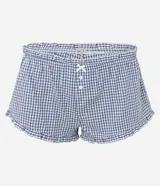 Pijama short doll de dos piezas confeccionado en algodón, con estampa de cuadros vichy en tonos azul y blanco. La musculosa presenta breteles finos, escote corazón con delicado encaje blanco y silueta fluida. El short cuenta con cintura elástica, pequeño moño frontal y terminación ondulada en el ruedo.