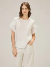 Blusa de lino color rosado, de corte recto y holgado, con cuello redondo y mangas cortas adornadas con volados.