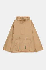 Cazadora tipo anorak de cuello subido con capucha ajustable mediante cordones elásticos y stoppers. Presenta manga larga, un bolsillo frontal de plastrón con solapa, y cintura y bajo ajustables con cordones elásticos. Cierre frontal con botones a presión.