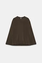 Blusa de cuello redondo y manga larga, confeccionada en tejido fluido con acabado satinado. Presenta un diseño de corte holgado, bajo recto y cierre en la espalda mediante una pequeña abertura con botón.