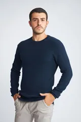 Sweater de punto color mostaza, con cuello redondo y mangas largas.