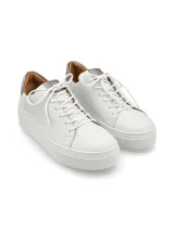 Sneaker de cuero graneado color blanco con plataforma elevada y detalle plomo en el talón. Cuenta con cordones de algodón al tono.