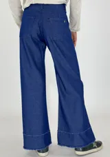 Pantalón de jean negro de corte acampanado con terminación desflecada en ruedo y cintura.