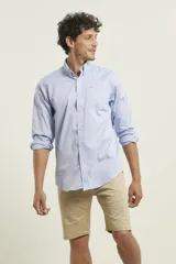 Camisa celeste de algodón con cuello abotonado, manga larga con puños abotonados y bolsillo en el pecho. Corte clásico.