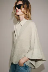 Camisa de mezcla de algodón de corte oversize y diseño asimétrico en tono azul, con cuello solapa, mangas tipo kimono por debajo del codo y cierre lateral con botones.