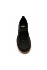 Zapatilla tipo chatita o ballerina color beige, con tiras cruzadas elásticas sobre el empeine, detalles en gamuza y suela de goma marrón con textura.