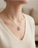Collar de acero con dije en forma de gota adornado con circonias pavé y una piedra central colgante.