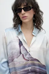 Camisa celeste de manga larga con estampa de paisaje.