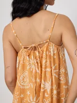 Vestido corto color naranja con estampado de motivos playeros en blanco, de breteles finos y corte suelto.