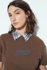 Remera blanca de manga corta con cuello redondo, aberturas laterales y bordado frontal con la frase "LIMITED EDITION" en negro.