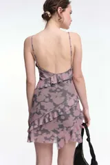 Vestido corto de tirantes finos con estampado de cebra en blanco y negro, escote en V y espalda baja. Presenta volados y frunces que realzan la figura.