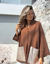 Saco tejido de punto en color marrón chocolate, con corte holgado y mangas anchas. Presenta cierre frontal con botones y dos bolsillos delanteros grandes en material metalizado color champán.