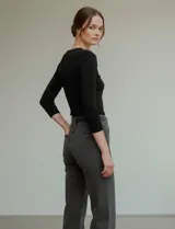 Remera de manga tres cuartos, color negro, confeccionada en modal, con cuello redondo ajustado a la base.