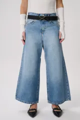 Pantalón de jean celeste de corte ancho con cinturón negro.