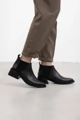 Botineta de cuero negro con textura sutil, con elásticos laterales y taco cuadrado bajo.