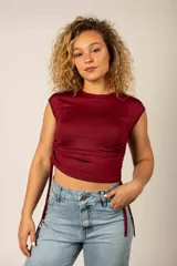 Remera entallada bordó sin mangas, con cuello redondo y frunces ajustables con tiras en los costados.