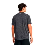 Remera deportiva Under Armour de manga corta, con cuello redondo y diseño jaspeado en tonos negros y grises. Presenta el logo de la marca estampado en el pecho.