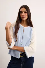 Saco de algodón tejido, color beige con mangas y detalles en blanco, escote en V y cierre frontal de botones.