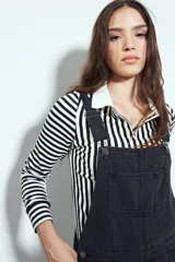 Remera de manga larga a rayas verticales verdes y blancas, con cuello polo y cierre frontal de botones. Presenta un diseño ajustado al cuerpo.